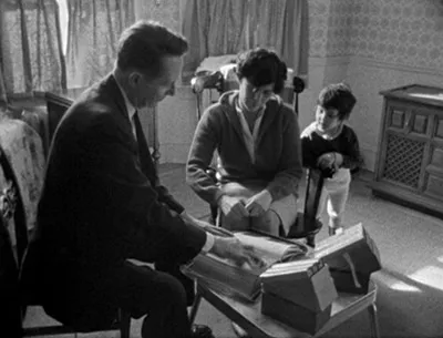 A still from the Maysles' brothers' 1968 documentary Salesman, about door-to-door Bible salesman, showing a salesman in a private home attempting to sell the company's wares.